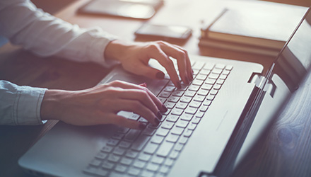 Hands Typing on Laptop