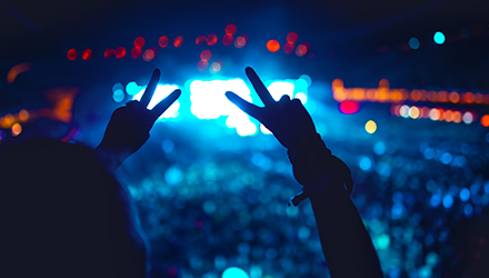 Person at a Concert with Peace Signs Up