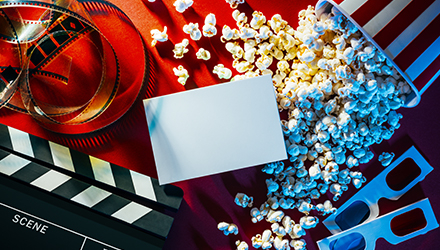 Movie popcorn, clapperboard, and reel