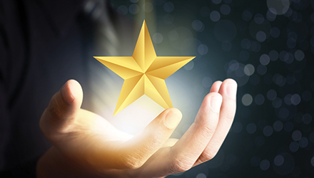 Person holding gold star