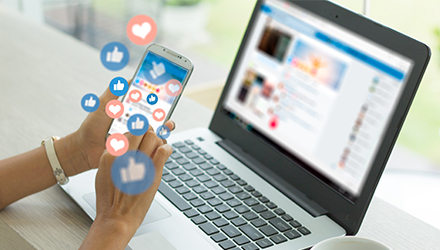 Person using social media on phone and laptop
