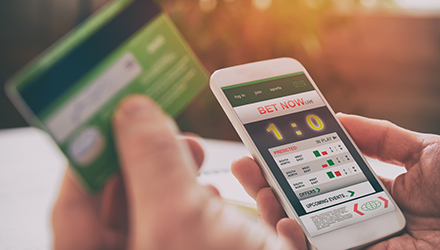 Person sports betting on phone
