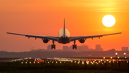 Airplane taking off in sunset