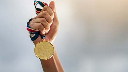 Hand holding gold medal