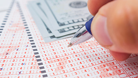 Male Hand Marking Number on Lottery Ticket