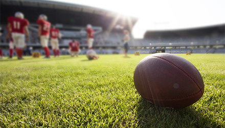 Football on field with team in the background