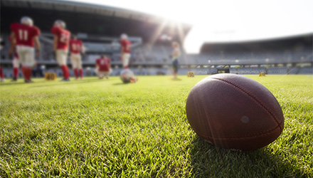 Football on field with team in the background