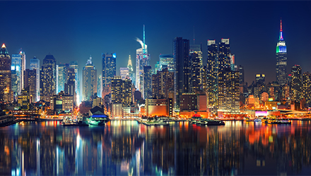 New York City at Night With Building Lights Reflecting Off of a Body of Water