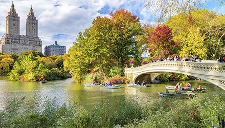 New York River with People Riding in Canoes and Walking Across a Bridge