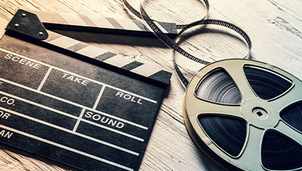 An Unraveled Film Reel Lying Next to a Clapperboard