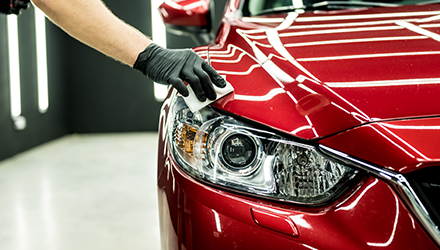 A Gloved Hand Wiping A Shiny Car